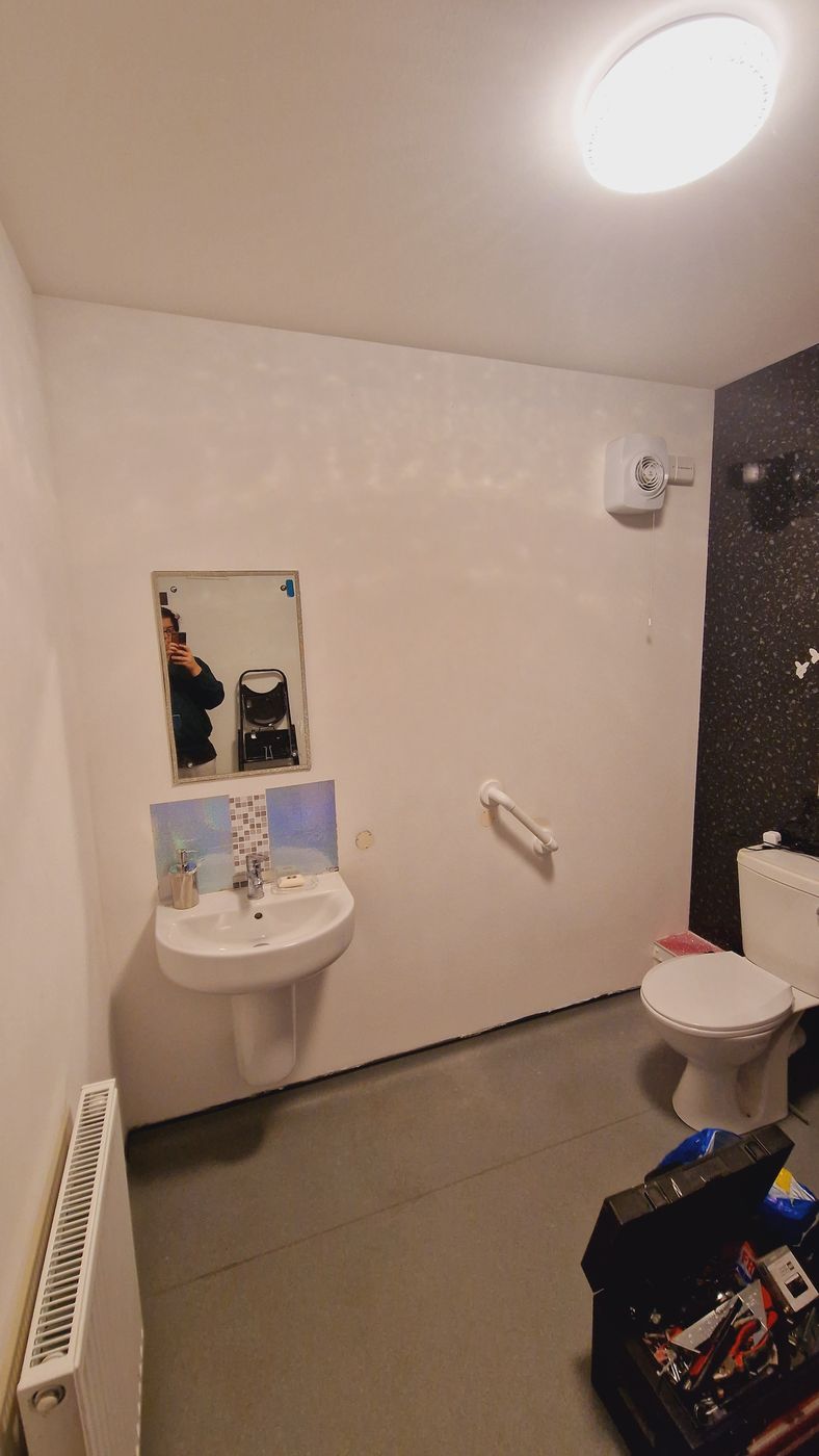Job E wall 1 before: plain white wall behind the basin and toilet