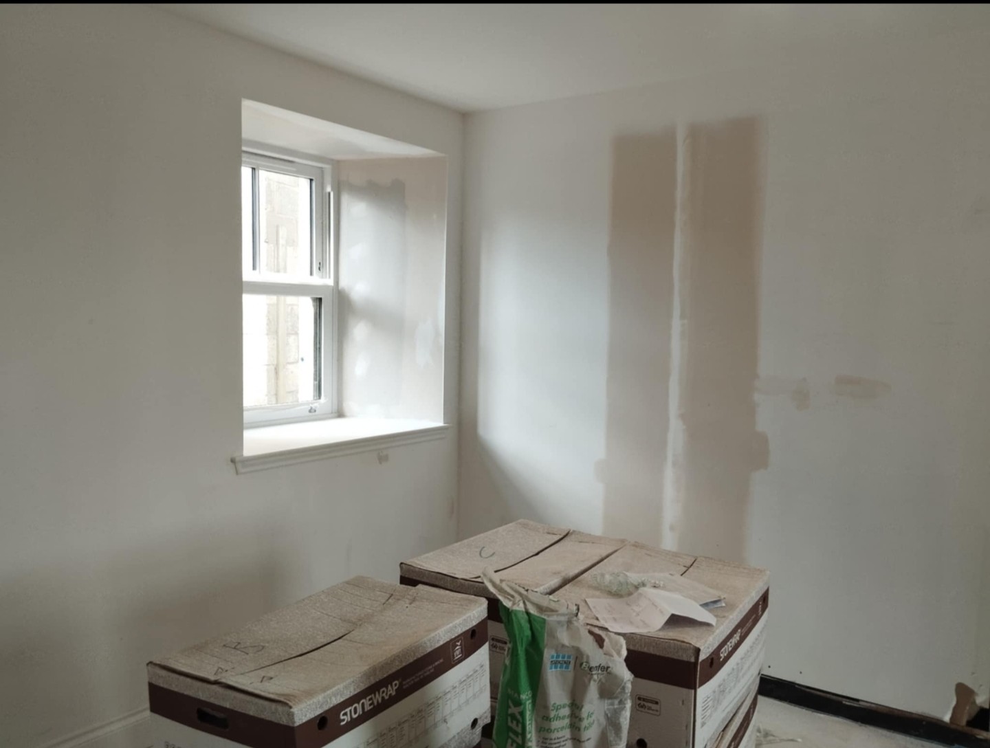 Job B before: patched white wall by the window