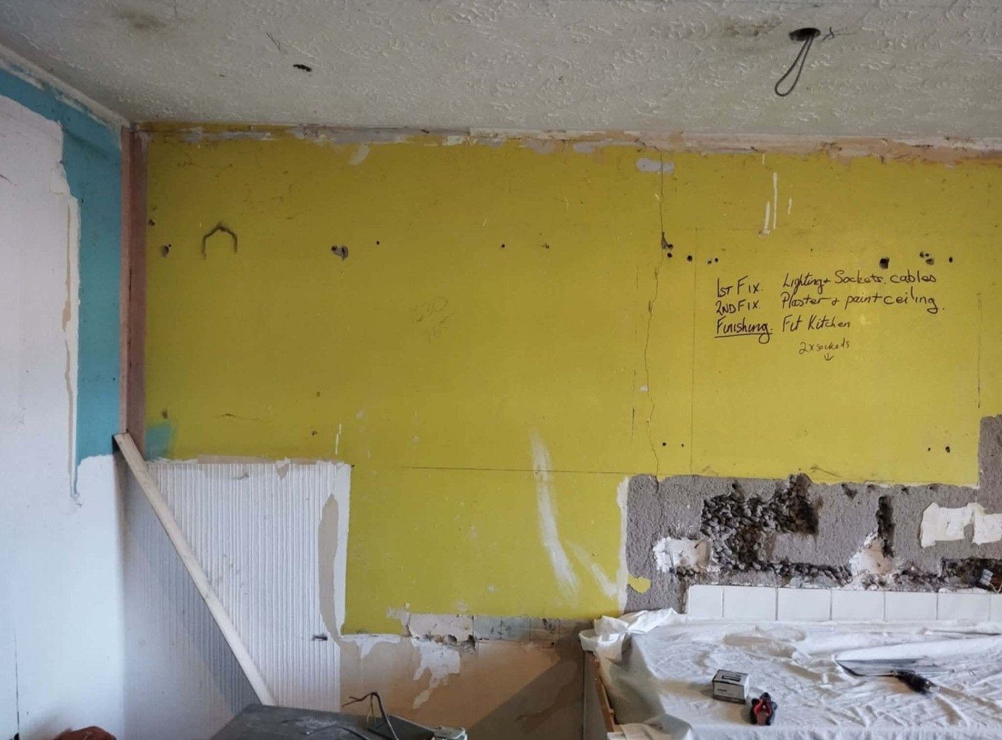 Job D before: kitchen wall stripped to the plaster