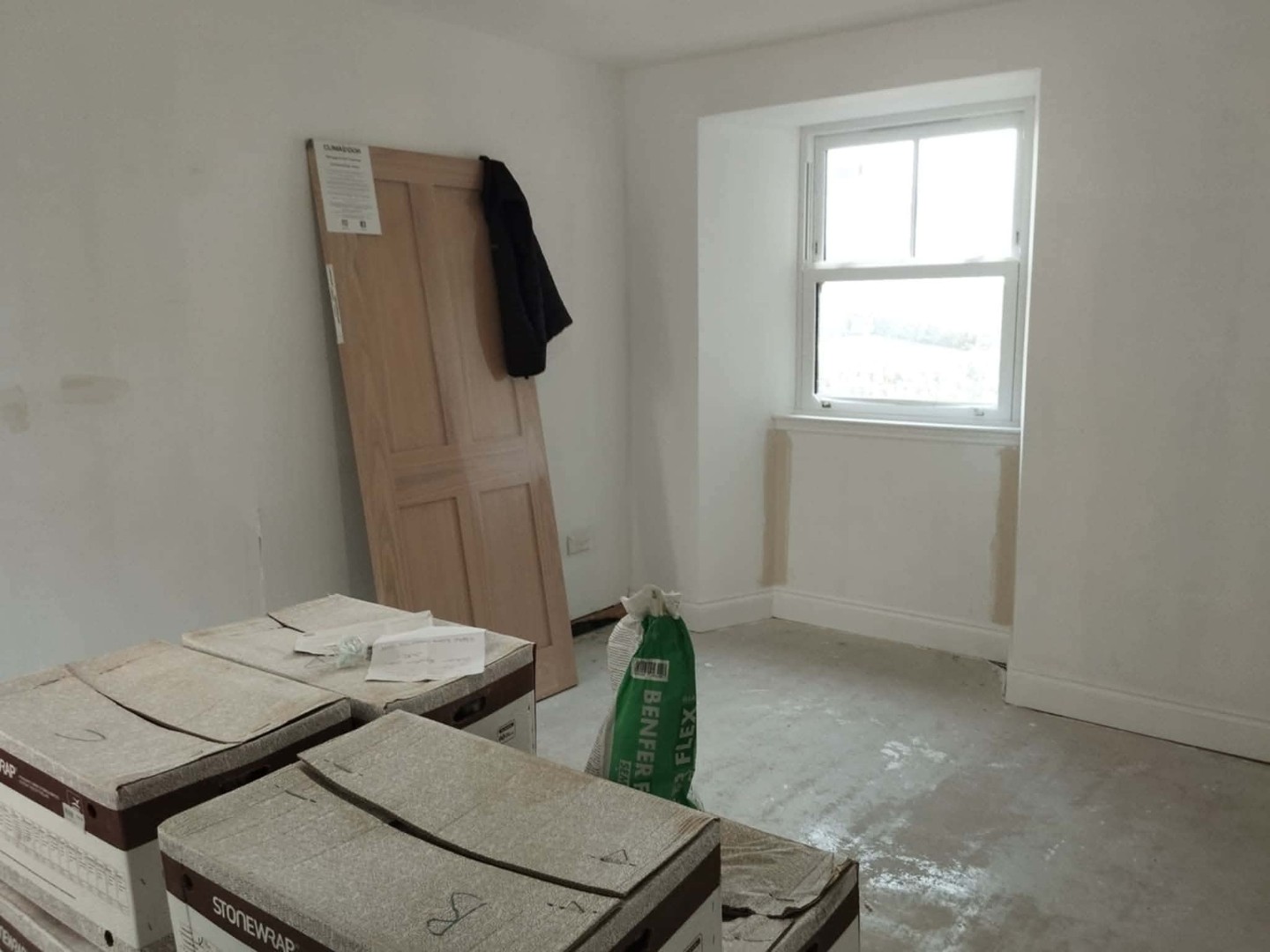 Job A before: bare white bedroom with materials on the floor