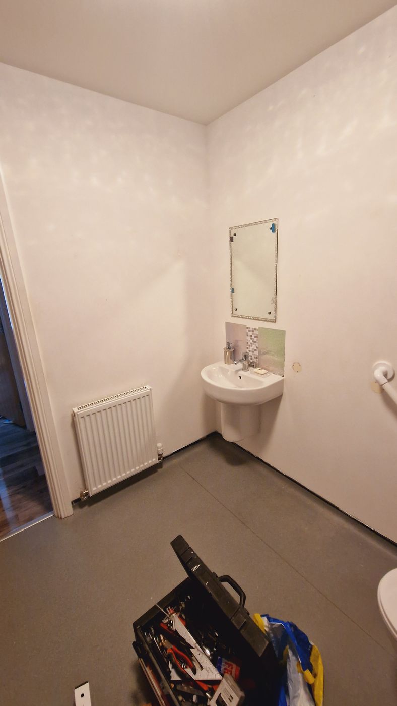 Job E wall 2 before: plain corner with radiator and basin