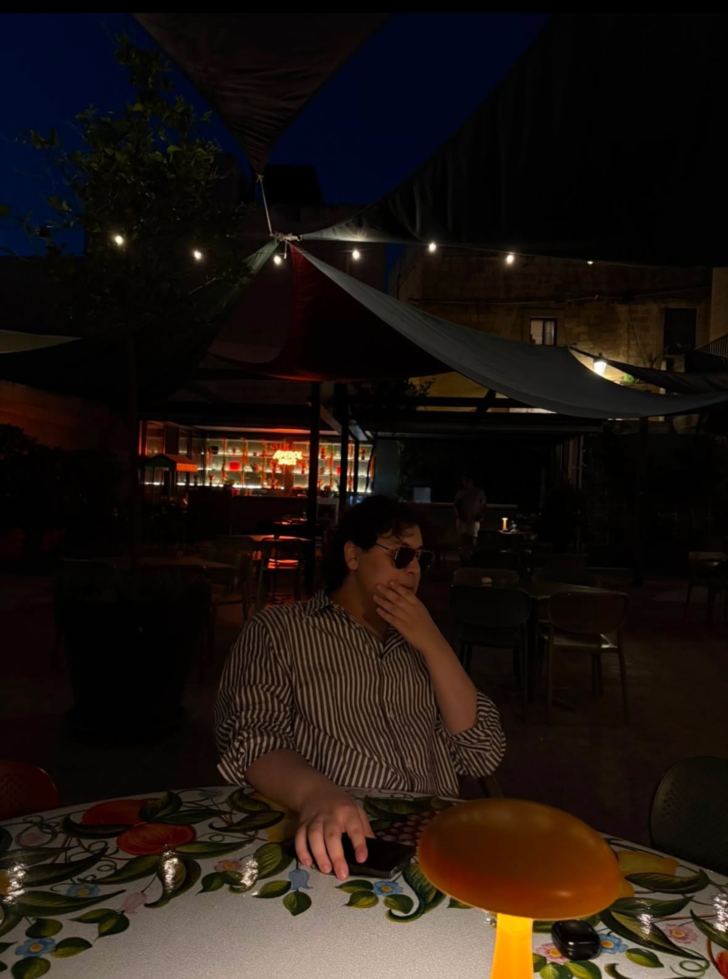 Samuels in sunglasses at a dinner table at night