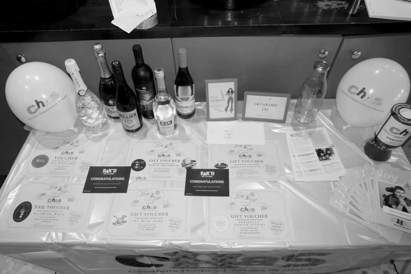 Raffle table with CHAS balloons, bottles and gift vouchers
