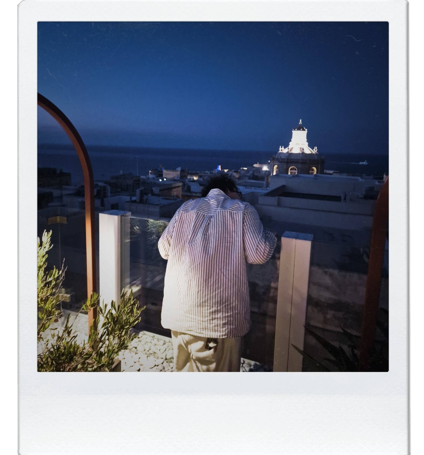 Polaroid of Samuels looking out over the sea at night